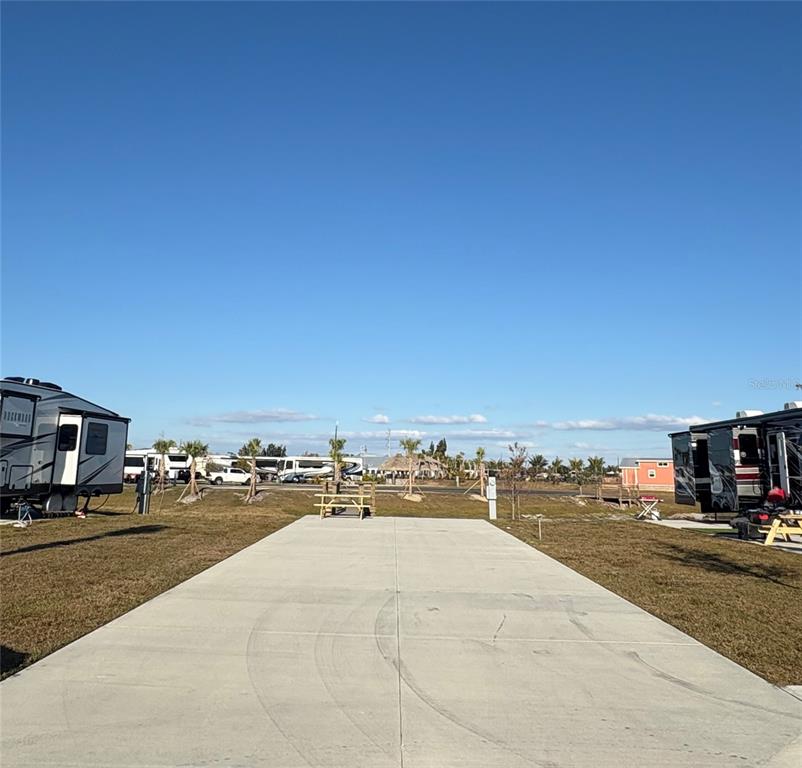 A concrete RV pad sits between two parked campers under a clear blue sky — 259 HORIZON ROAD, PUNTA GORDA, FL
