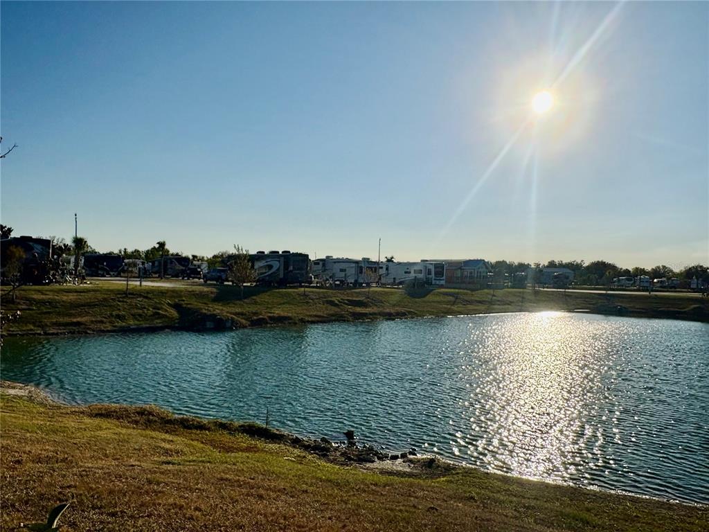A pond sits in the foreground with a row of parked RVs in the background — 259 HORIZON ROAD, PUNTA GORDA, FL