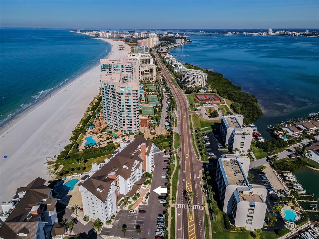 A screened-in balcony with tile flooring, a barrel table, and a view of the ocean — 1582 GULF BOULEVARD UNIT 1106, CLEARWATER BEACH, FL