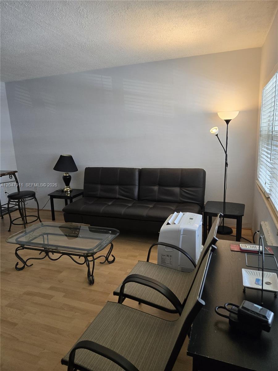 A living room features a dark leather sofa, a glass coffee table, and light flooring — 2001 S Ocean Dr # 41, Hallandale Beach FL 33009, HALLANDALE BEACH, FL