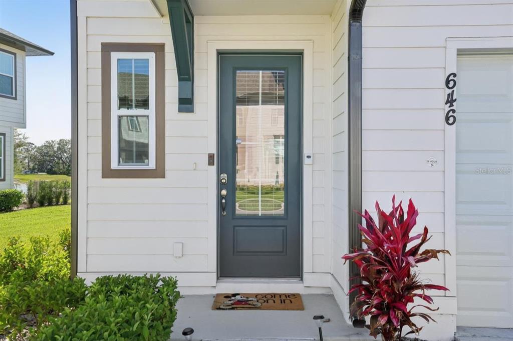 A front entrance with a dark gray door, a window, and a house number — 646 LONGBOAT DRIVE, DAVENPORT, FL