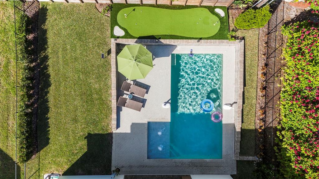 An aerial view shows a backyard with a swimming pool, patio, umbrella, and putting green — 2403 CAMBRIDGE AVENUE, LAKELAND, FL