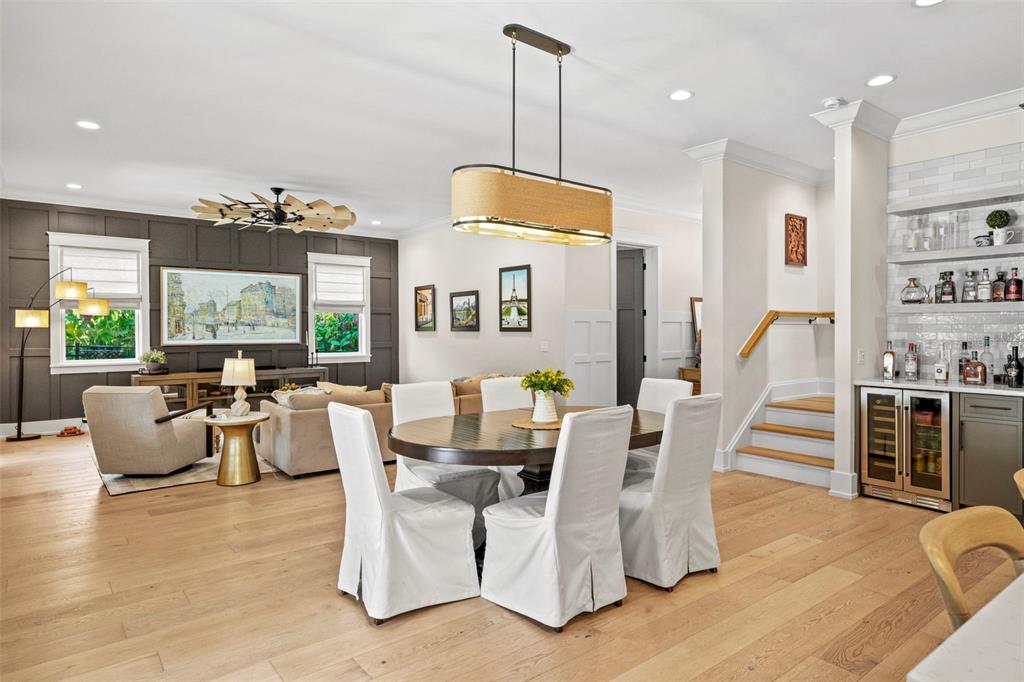 A dining area with a wooden table and white chairs sits beside a living room — 2403 CAMBRIDGE AVENUE, LAKELAND, FL