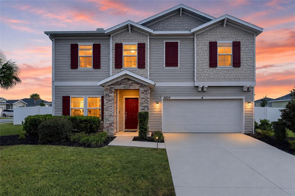 A two-story suburban house with gray siding, a stone entryway, and a two-car garage — 5624 SW 93RD STREET, OCALA, FL