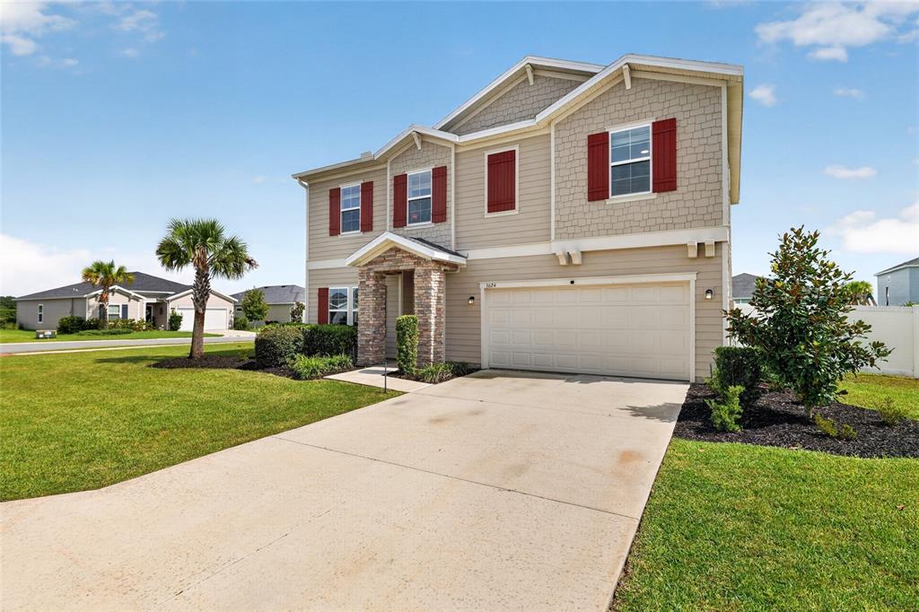 A two-story suburban house with tan siding, red shutters, and a two-car garage — 5624 SW 93RD STREET, OCALA, FL