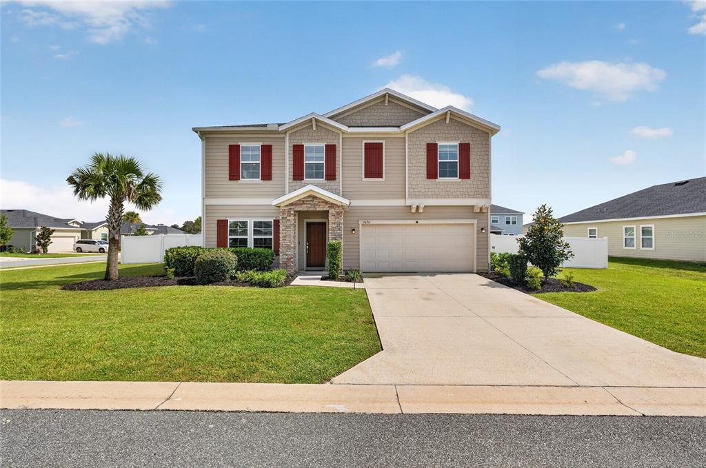 A two-story suburban house with beige siding, red shutters, and a two-car garage — 5624 SW 93RD STREET, OCALA, FL