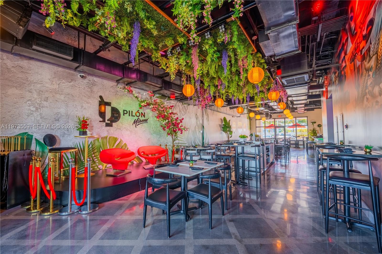 The interior of a restaurant features a floral ceiling, red accent chairs, and black furniture — 12850 sw 128th st, Miami FL 33186, MIAMI, FL