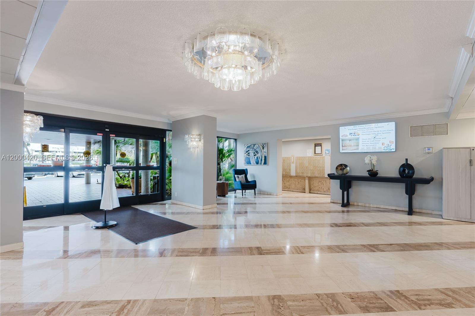 A bright building lobby features marble floors, a large crystal chandelier, and a reception area — 3800 Hillcrest Dr # 411, Hollywood FL 33021, HOLLYWOOD, FL