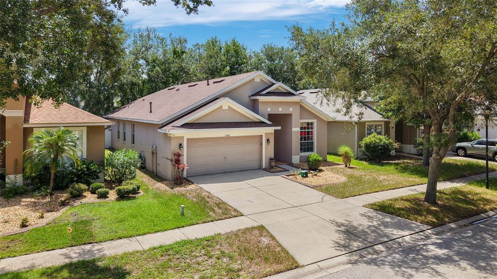A tan, single-story suburban house with a two-car garage and a concrete driveway — 13804 SIGLER STREET, RIVERVIEW, FL