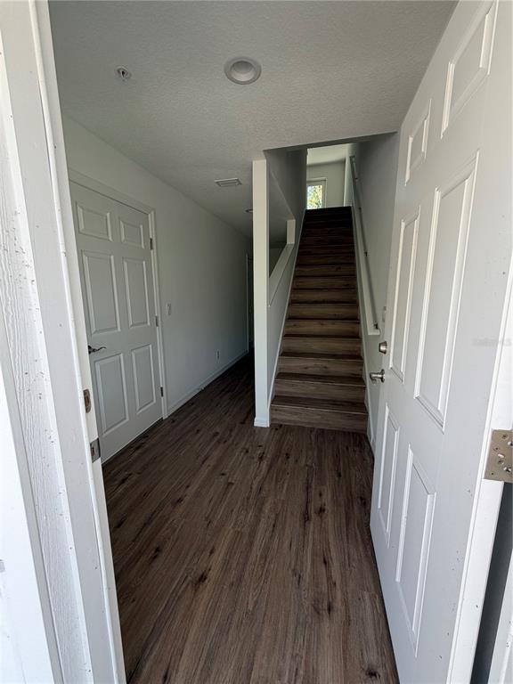 An entryway features wood-look flooring, a white door, and a staircase leading to an upper level — 2575 6TH AVENUE DRIVE E, BRADENTON, FL
