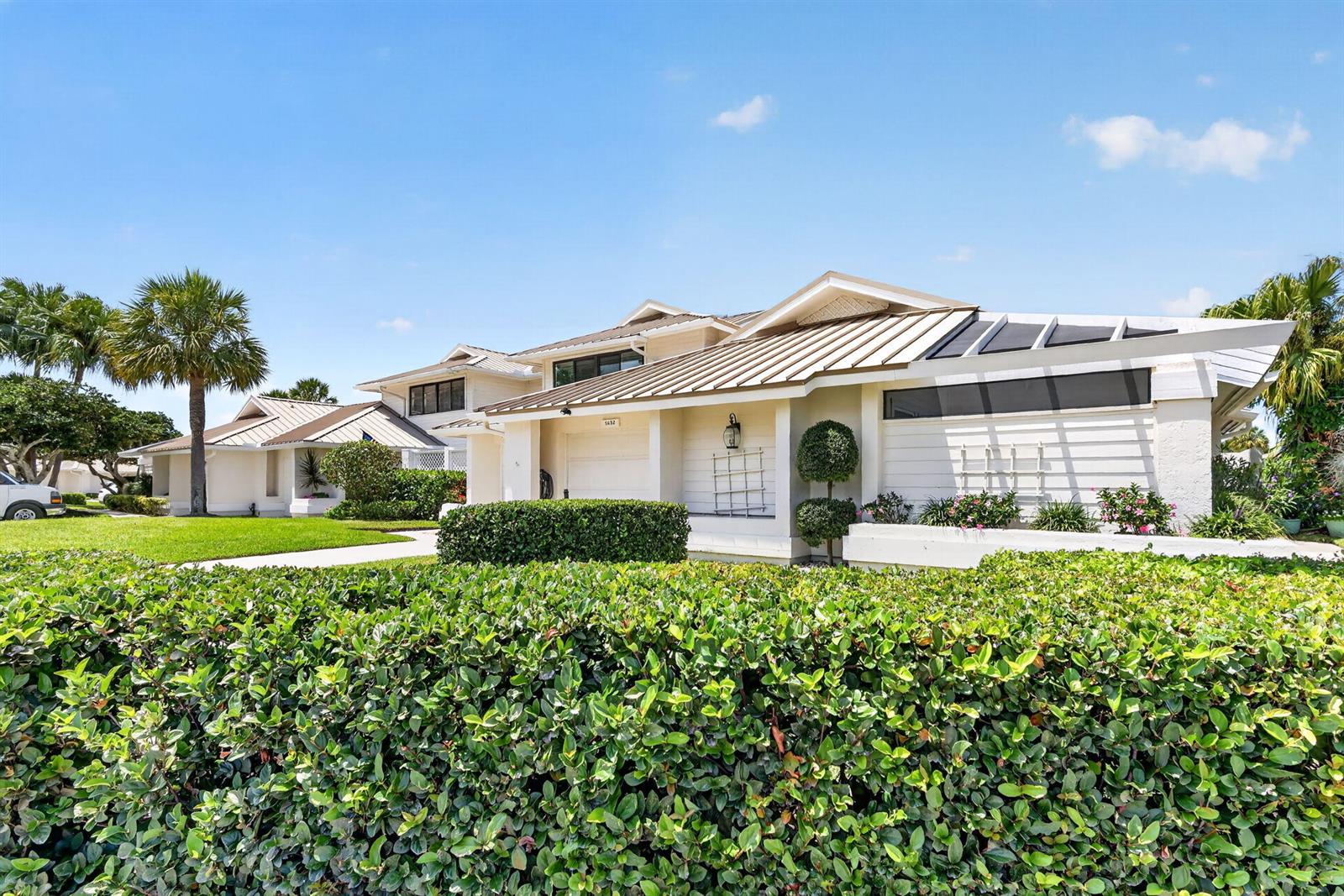 A kitchen features a white island, pink tile backsplash, white cabinetry, and a planked ceiling — 5632 SE Foxcross Place, Stuart FL 34997, STUART, FL