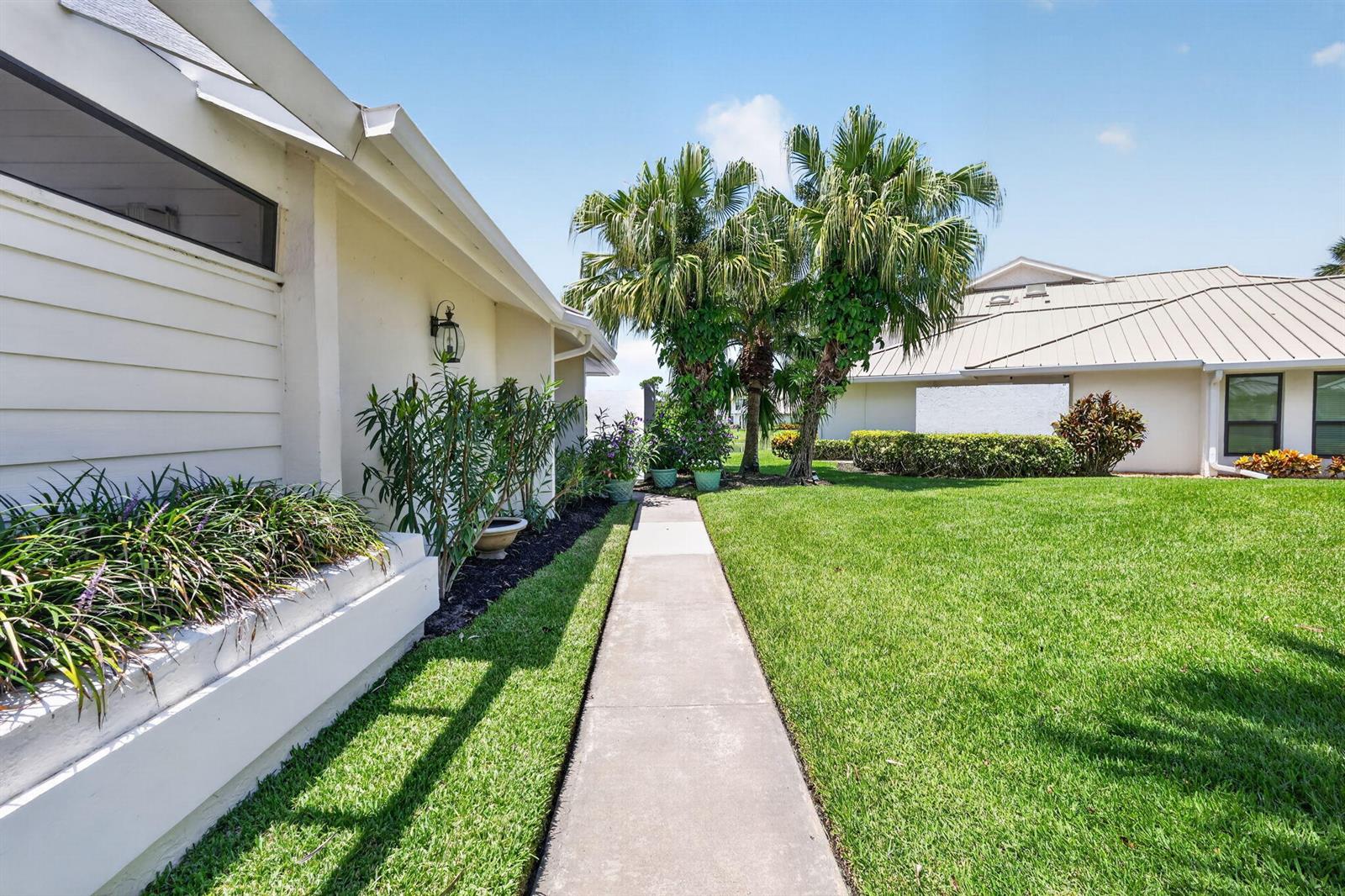 A kitchen features white cabinets, pink tile backsplash, marble countertops, and a white plank ceiling — 5632 SE Foxcross Place, Stuart FL 34997, STUART, FL