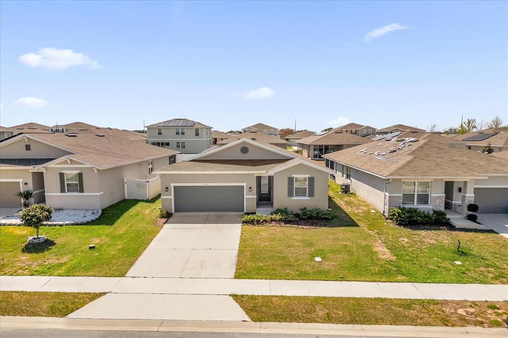 An aerial view of a single-story suburban house with a gray garage and tan siding — 551 LAKE SMART BOULEVARD, WINTER HAVEN, FL