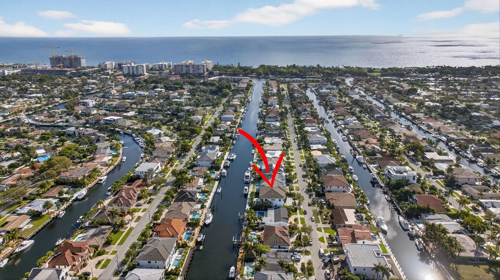 An aerial view shows a residential neighborhood with houses lining multiple canals near the ocean — 2641 NE 48th Street, Lighthouse Point FL 33064, LIGHTHOUSE POINT, FL