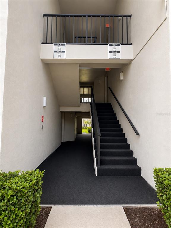 An exterior view of a building entrance with a black staircase and a metal railing — 1223 S PINE RIDGE CIRCLE UNIT 23, SANFORD, FL