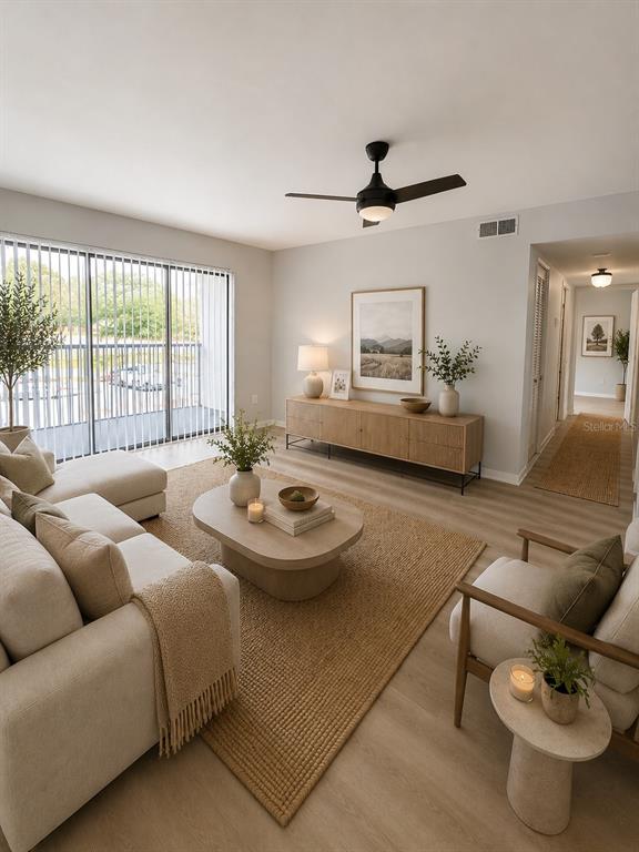 A living room features light wood flooring, a neutral sofa, an oval coffee table, and balcony — 1223 S PINE RIDGE CIRCLE UNIT 23, SANFORD, FL