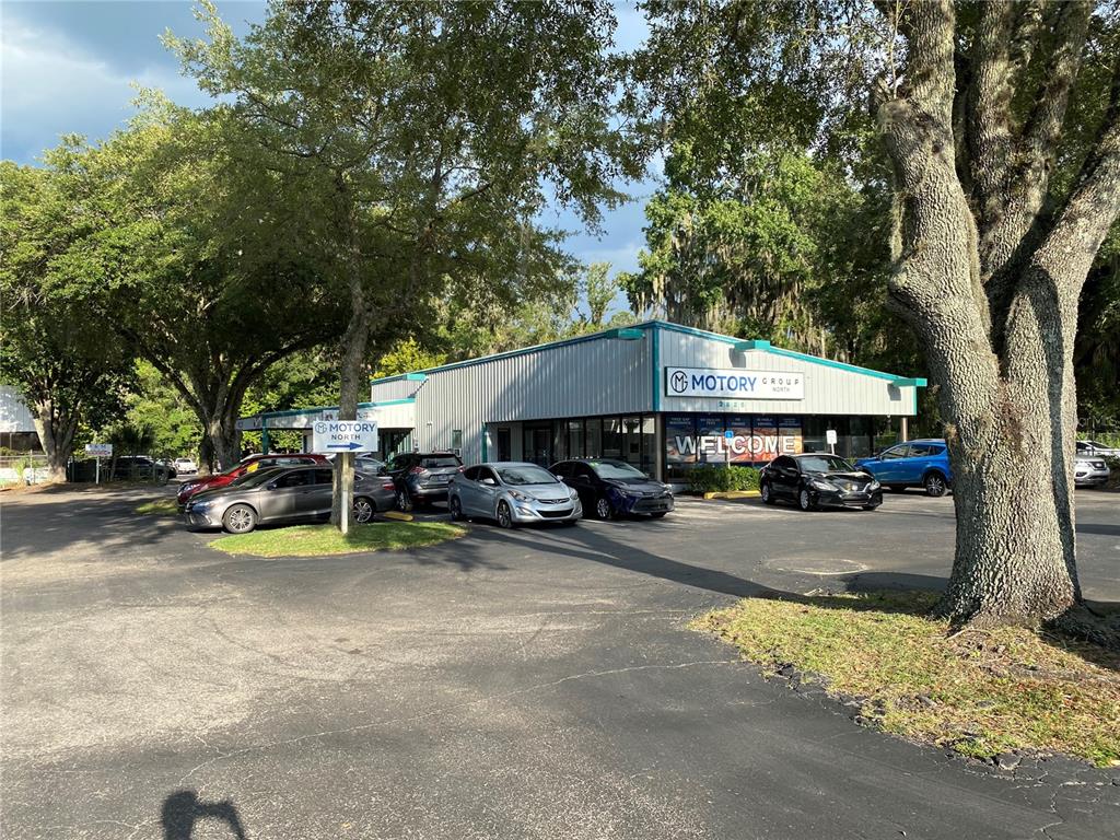 A car dealership building with a parking lot and surrounding trees — 2625 N MAIN STREET, GAINESVILLE, FL