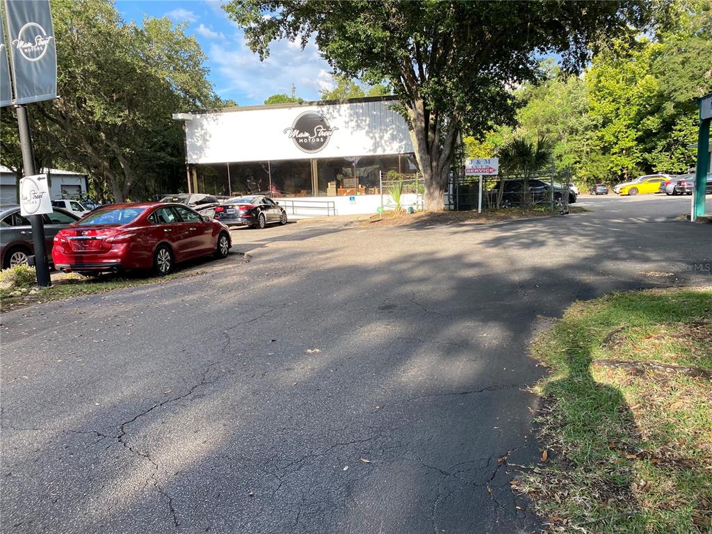 A view of a commercial building with a parking lot and several parked cars — 2625 N MAIN STREET, GAINESVILLE, FL