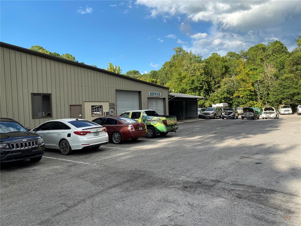 An exterior view of a commercial building with a service bay and a parking lot — 2625 N MAIN STREET, GAINESVILLE, FL