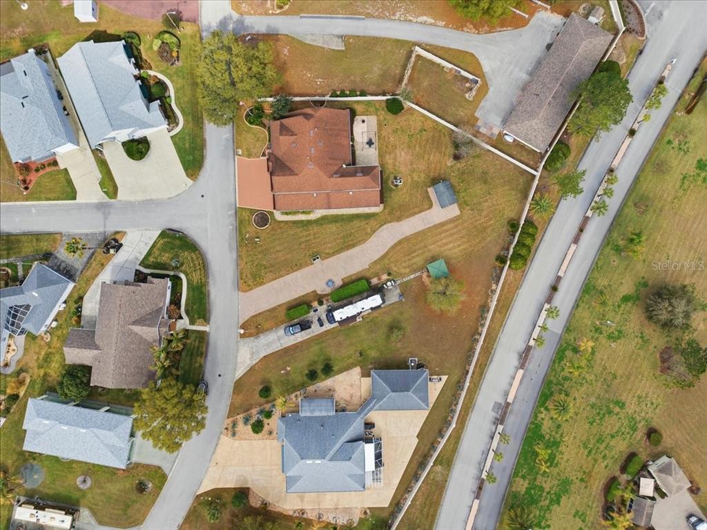 An aerial view shows several houses with driveways and lawns in a suburban neighborhood — MOTORCOACH DRIVE S, POLK CITY, FL