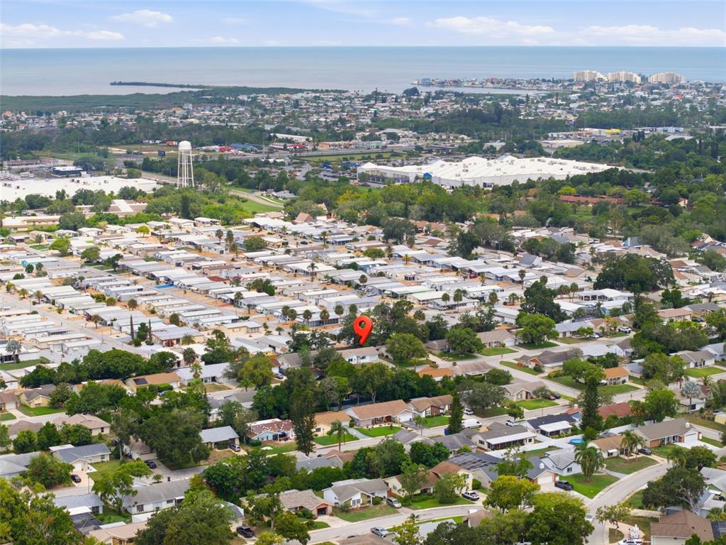 An aerial view shows a residential neighborhood with a red location pin on a house — 12305 PARTRIDGE HILL ROW, HUDSON, FL