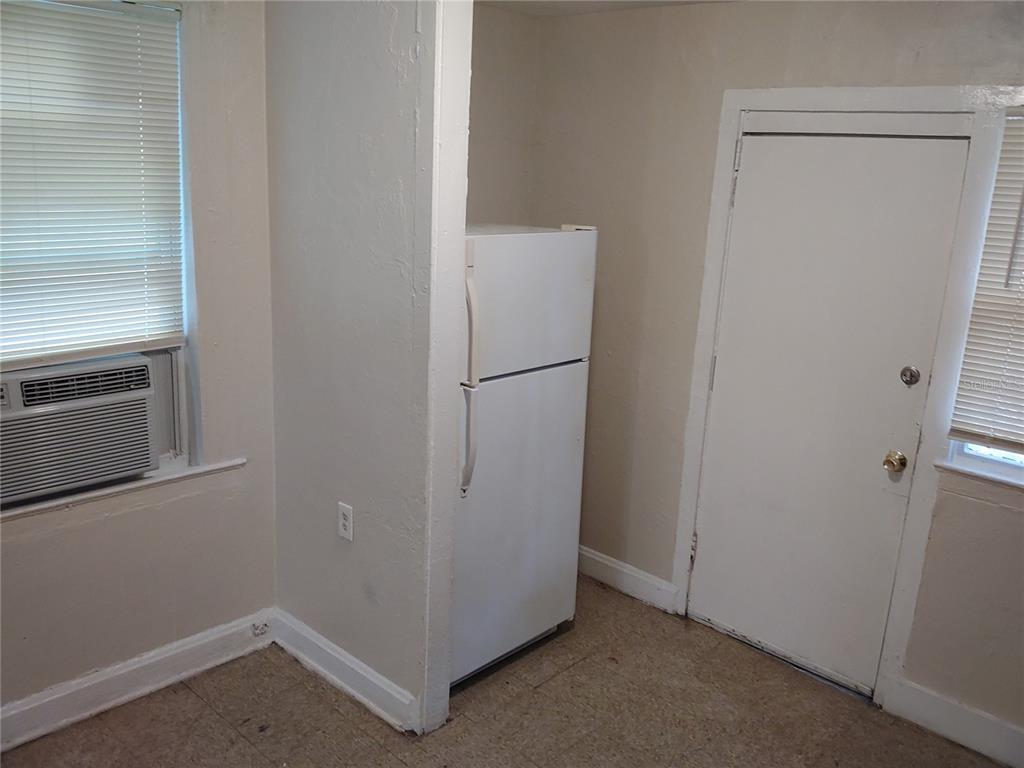 A room with a white refrigerator, a window air conditioning unit, and a white door — 1911 W 26TH STREET, JACKSONVILLE, FL