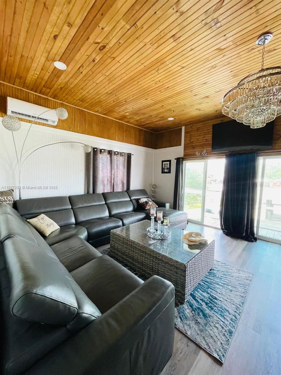 A living room features a large leather sectional, a glass-topped coffee table, and wood-paneled ceilings — 0 Main Grade Rd, Frostproof FL 33843, FROSTPROOF, FL