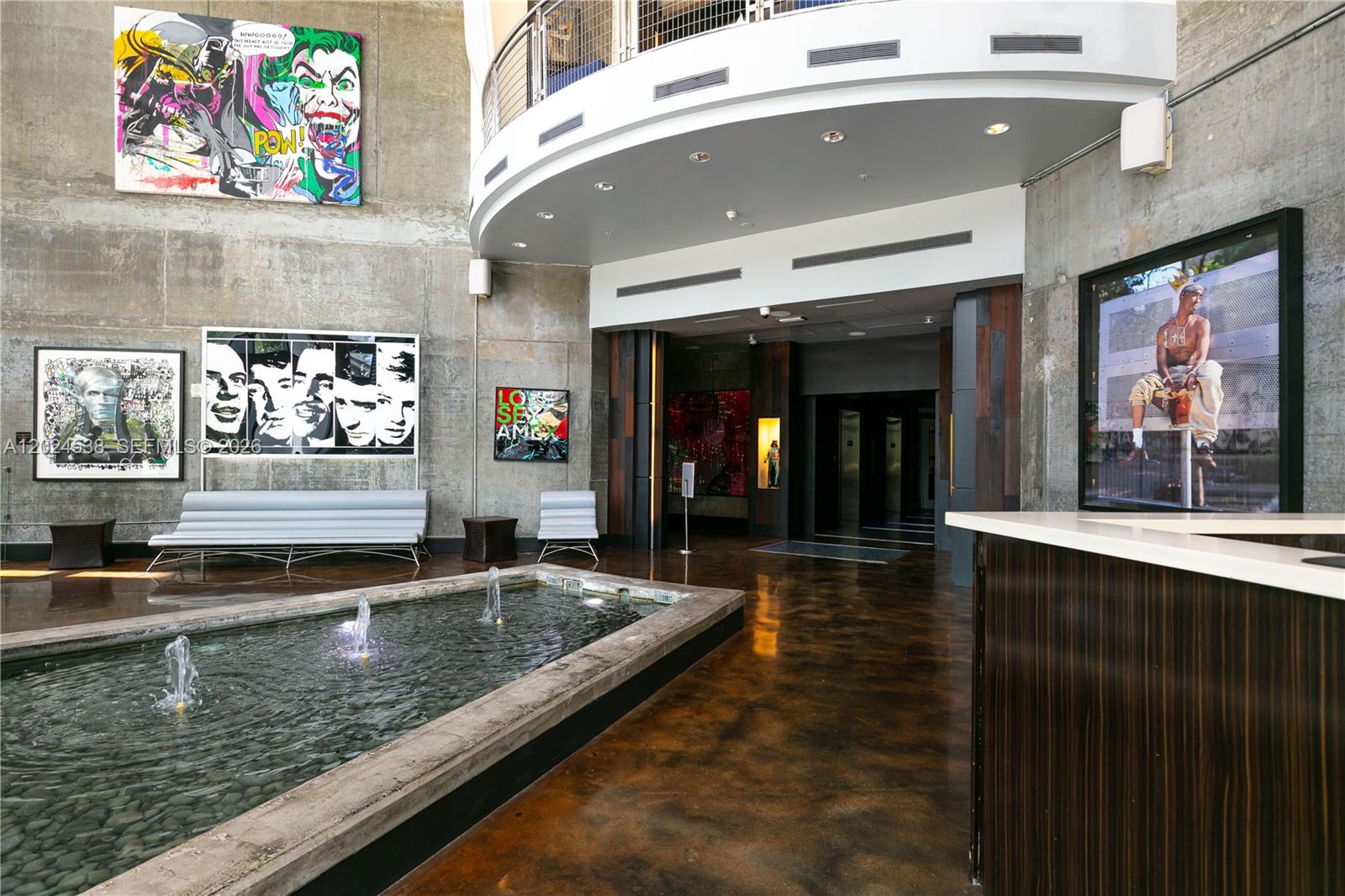 A modern lobby features a stone fountain, concrete walls, pop art, and a reception desk — 690 SW 1st Ct, Miami FL 33130, MIAMI, FL
