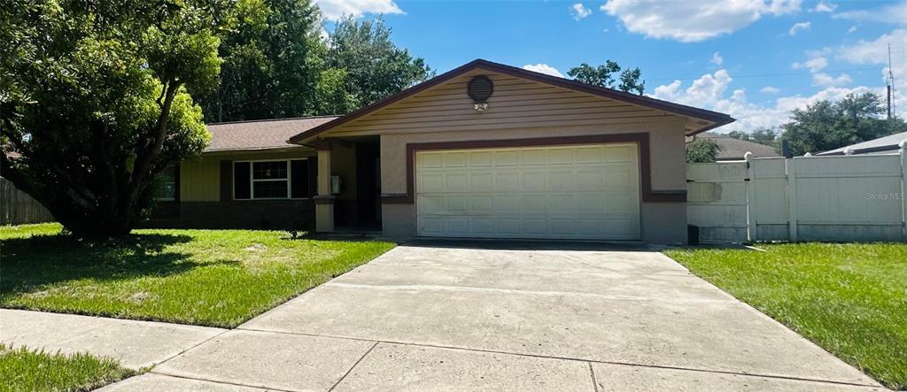 A single-story house with a two-car garage, concrete driveway, and a white vinyl fence — 5354 LANYARD COURT, WINTER PARK, FL