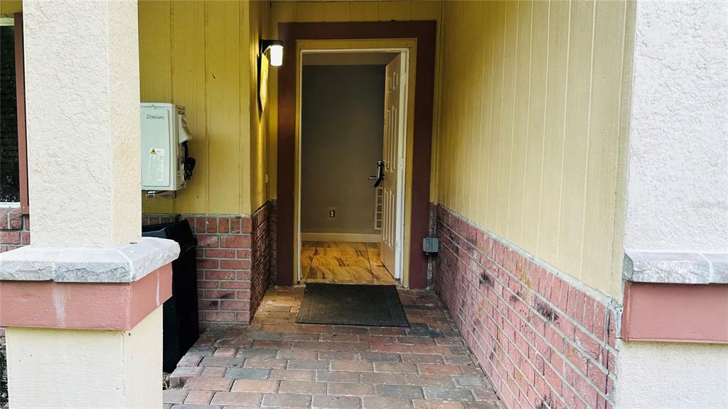A brick-paved entryway leads to an open front door revealing a tiled interior hallway — 5354 LANYARD COURT, WINTER PARK, FL