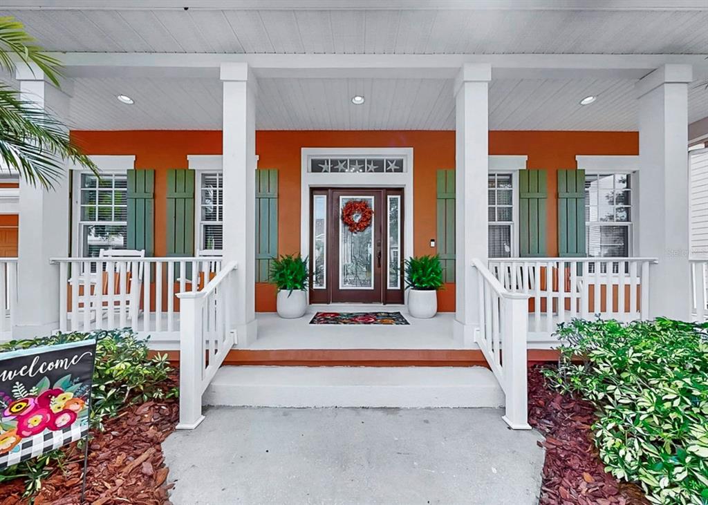 A single-story orange house with a front porch, palm trees, and a landscaped yard — 5715 SEA TROUT PLACE, APOLLO BEACH, FL