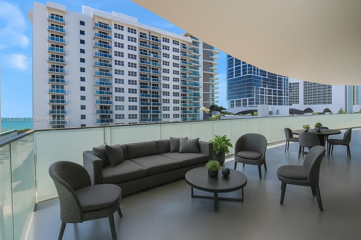 A spacious balcony features modern outdoor furniture, a glass railing, and views of nearby high-rise buildings — 6930 Collins Ave, Miami Beach FL 33141, MIAMI BEACH, FL