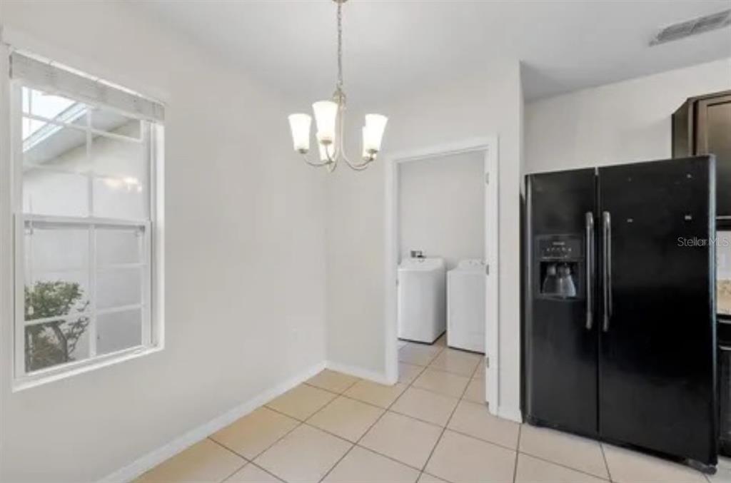 An open-concept kitchen with a breakfast bar, light-colored walls, and wood-look flooring — 724 LAKE CUMMINGS BOULEVARD, LAKE ALFRED, FL