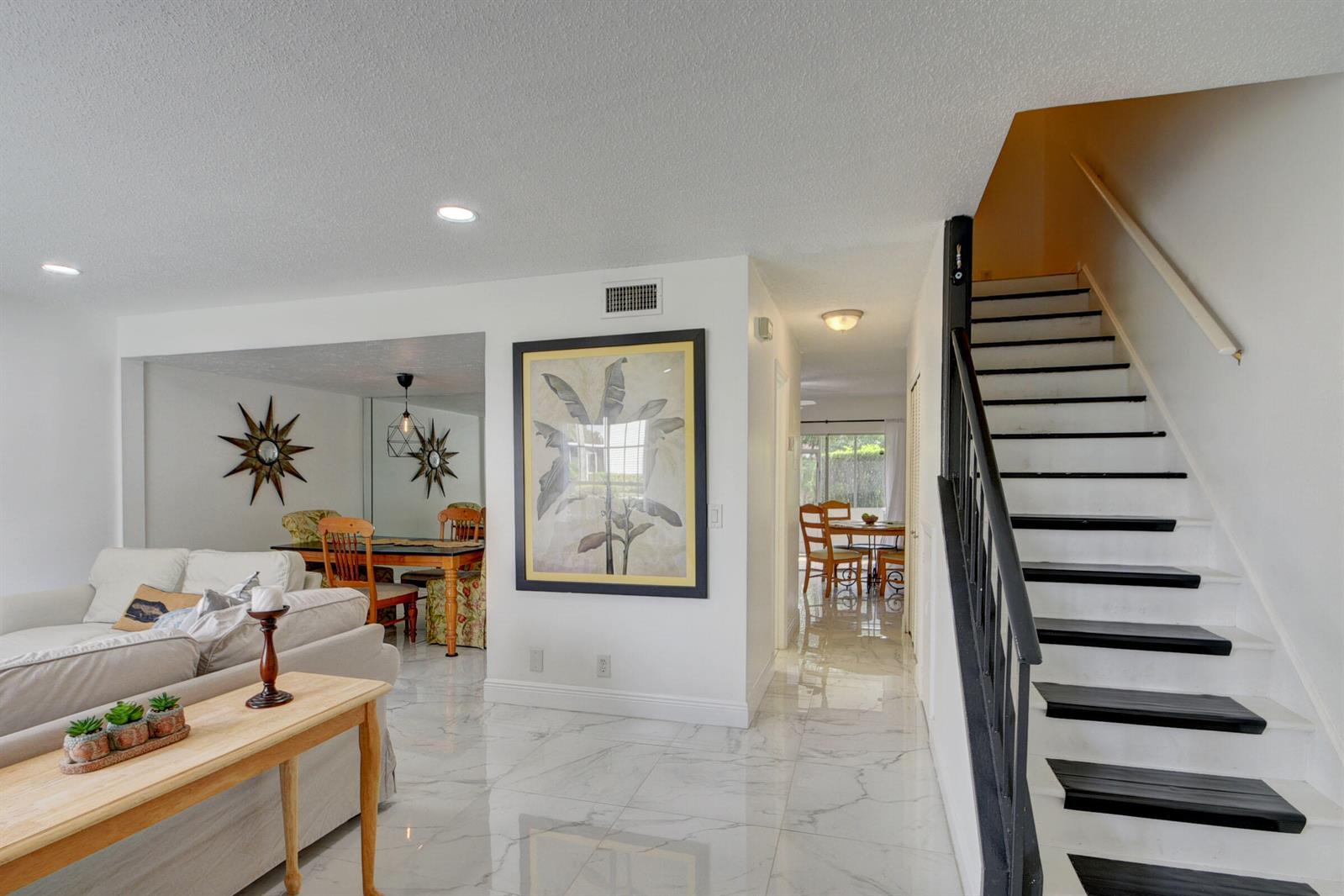 A living room with white tile floors and a staircase leads to a dining area — 11862 E Brier Patch Ct Court, Wellington FL 33414, WELLINGTON, FL