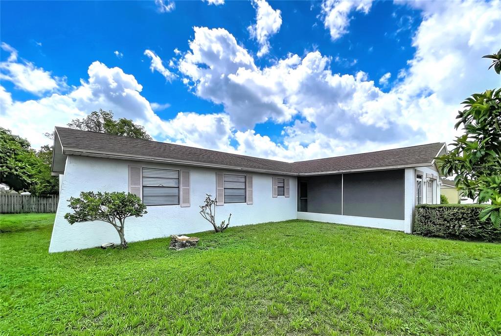 A white house with a screened-in porch and a grassy yard under a cloudy sky — 12132 SHADOW RIDGE BOULEVARD, HUDSON, FL