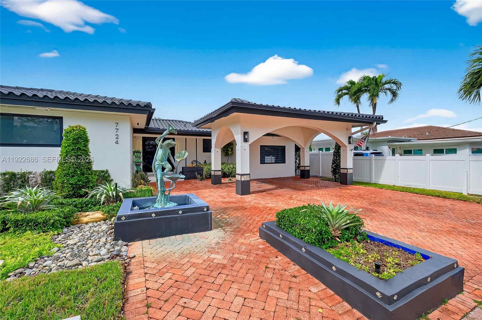 A single-story house features a brick driveway, a covered entryway, and a decorative fountain — 7724 Hawthorne Ave, Miami Beach FL 33141, MIAMI BEACH, FL