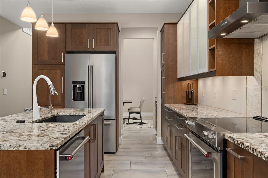 A modern kitchen features wood cabinets, granite countertops, stainless steel appliances, and a central island — 3526 E CRYSTAL LAKE AVENUE, ORLANDO, FL