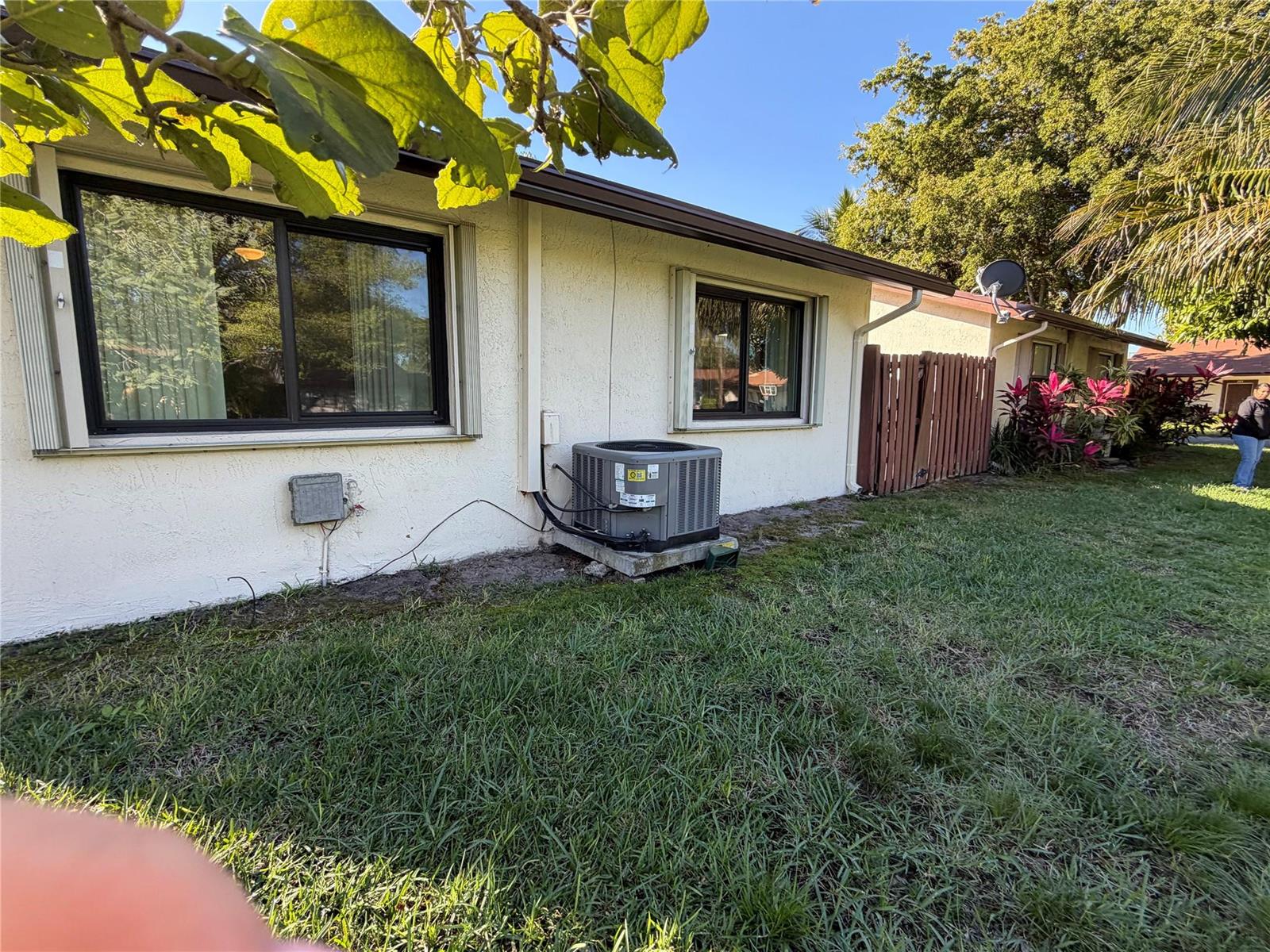 The exterior of a house features a stucco wall, two windows, and an air conditioning unit — 6711 S Parkway Drive # 10, Margate FL 33068, MARGATE, FL