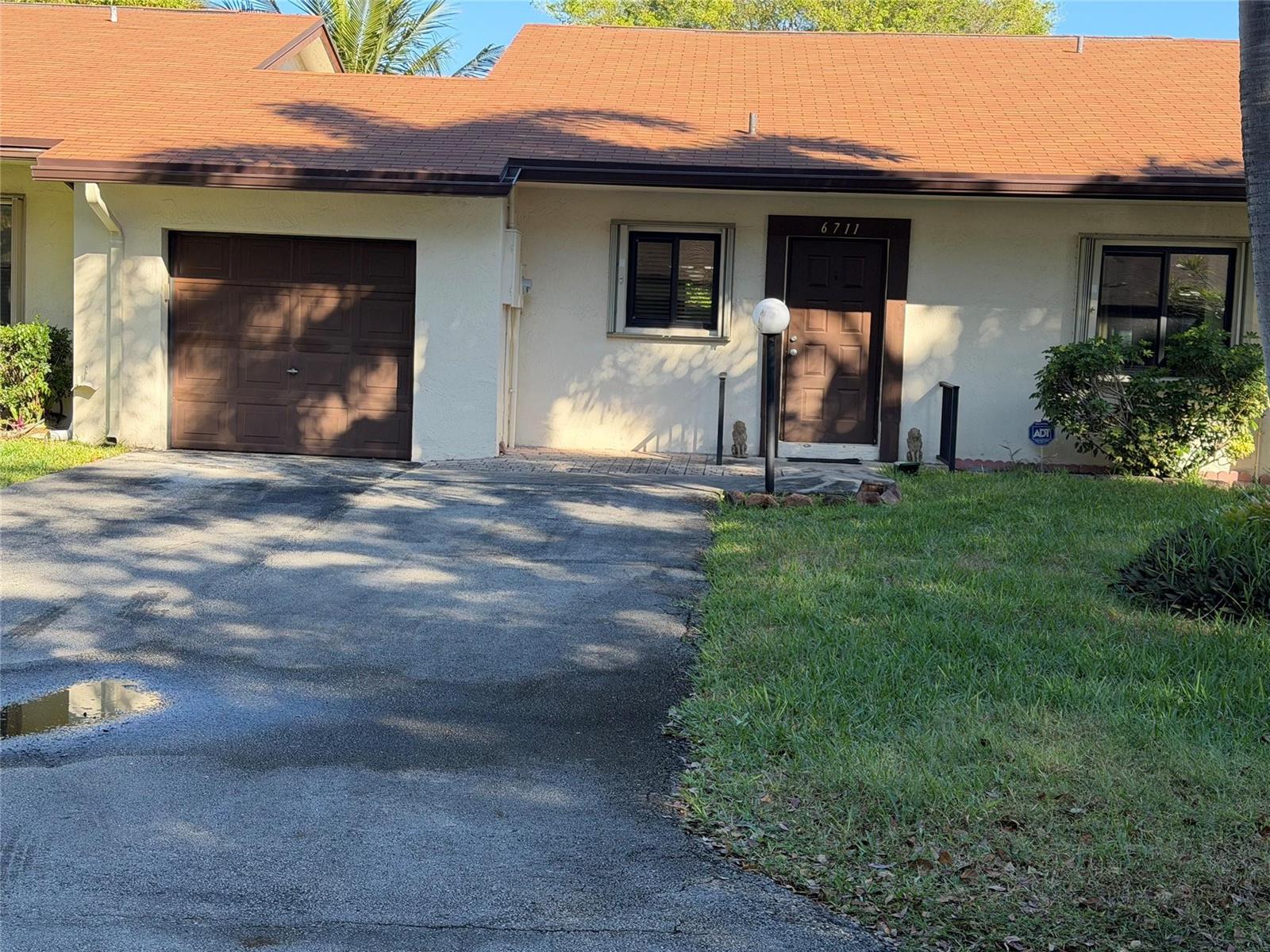 A single-story house with a brown roof, beige stucco walls, a garage, and a front door — 6711 S Parkway Drive # 10, Margate FL 33068, MARGATE, FL