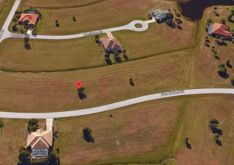 This is an aerial map view of a vacant residential lot marked with a red pin — 24465 SAN RAFAEL ROAD, PUNTA GORDA, FL