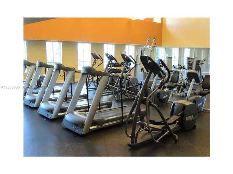 A gym room features several treadmills and elliptical machines on a dark floor — 7350 SW 89th St # 505S, Miami FL 33156, MIAMI, FL