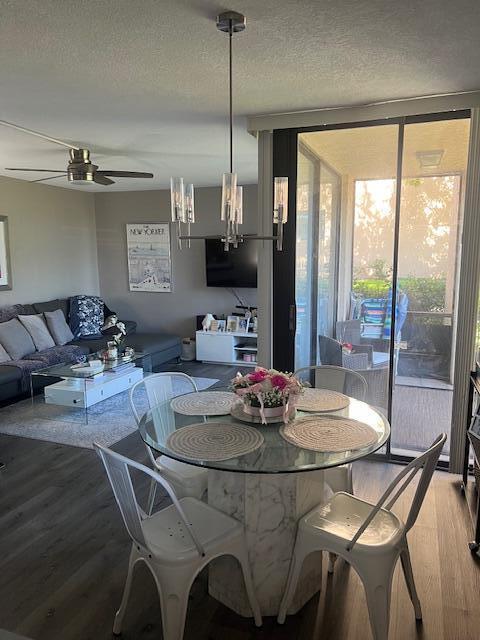 A dining area with a glass-top table and white metal chairs sits beside a living room — 955 Dotterel Road # 2111, Delray Beach FL 33444, DELRAY BEACH, FL