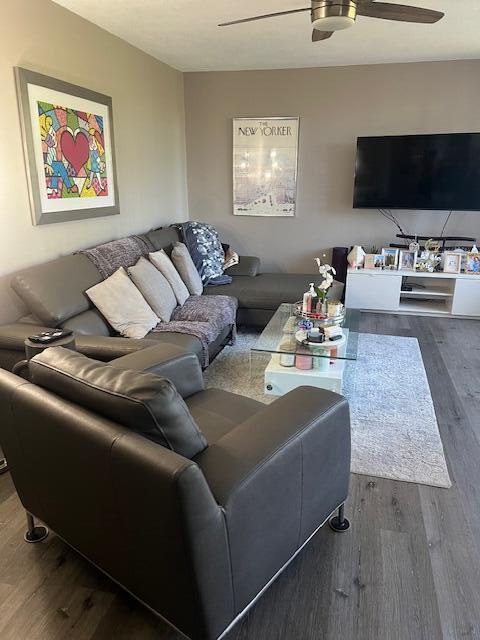 A living room features a grey sectional sofa, a matching armchair, and a television console — 955 Dotterel Road # 2111, Delray Beach FL 33444, DELRAY BEACH, FL