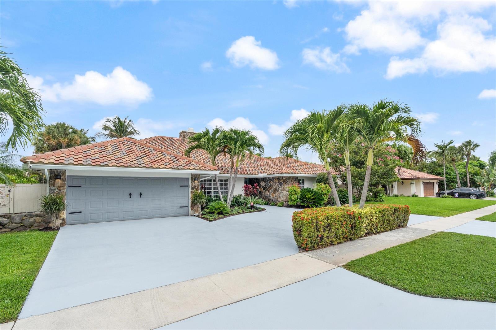 A single-story house with a tiled roof, stone facade, and a gray garage door — 2069 SW 7th Court, Boca Raton FL 33486, BOCA RATON, FL