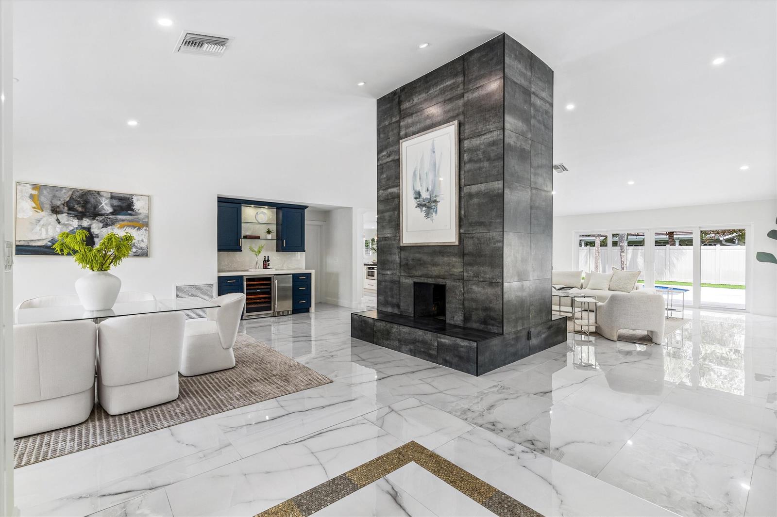 A dining area and living room are separated by a large, dark tiled central fireplace — 2069 SW 7th Court, Boca Raton FL 33486, BOCA RATON, FL