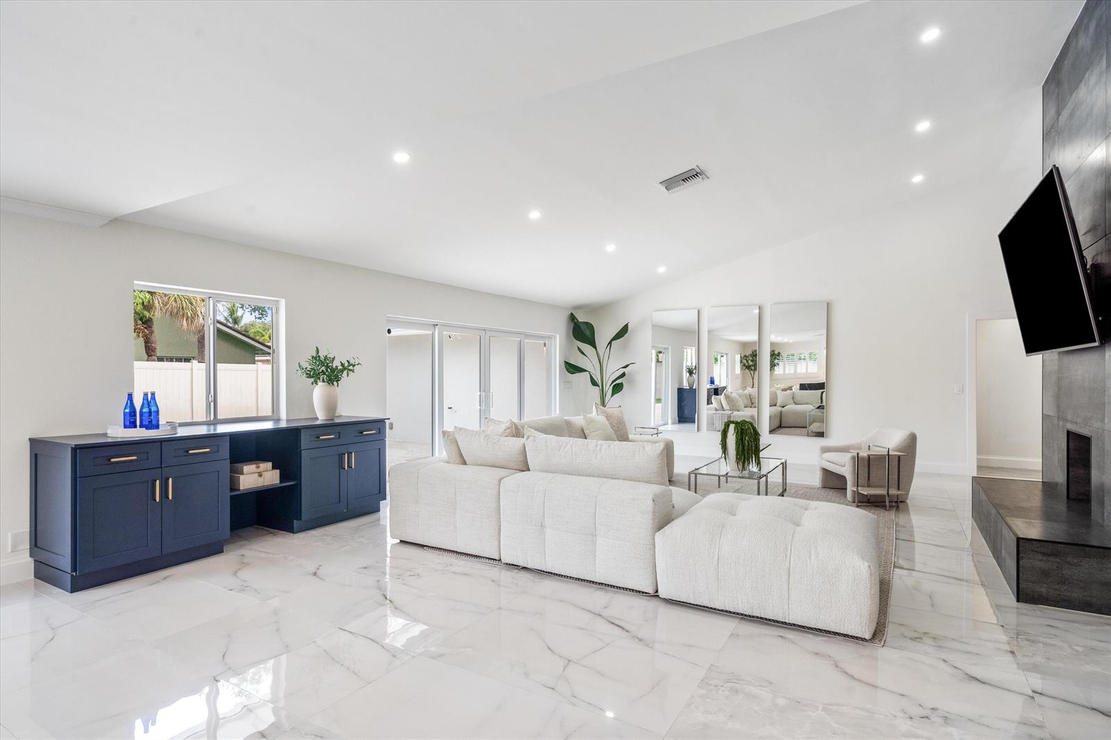 A modern living room features a white sectional sofa, blue cabinetry, and marble tile flooring — 2069 SW 7th Court, Boca Raton FL 33486, BOCA RATON, FL