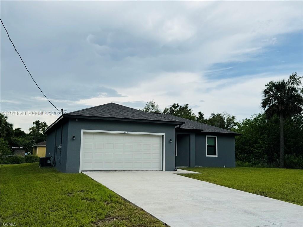 A single-story gray house with a two-car garage and a concrete driveway — 6018 ACORN CIR, La Belle FL 33935, LA BELLE, FL