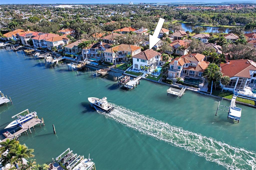 An aerial view shows a waterfront house with a pool and dock along a canal — 4635 DOLPHIN CAY LANE S, ST PETERSBURG, FL