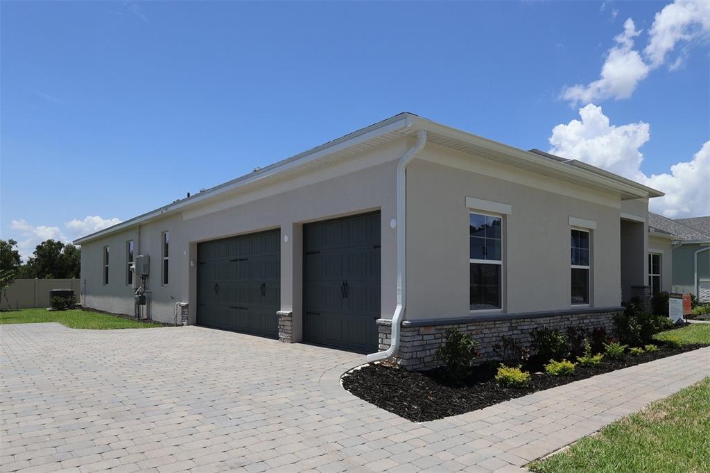 A kitchen with wood cabinets, white countertops, a large island, and light-colored tile flooring — 3811 WOLVES CREEK PLACE, APOPKA, FL