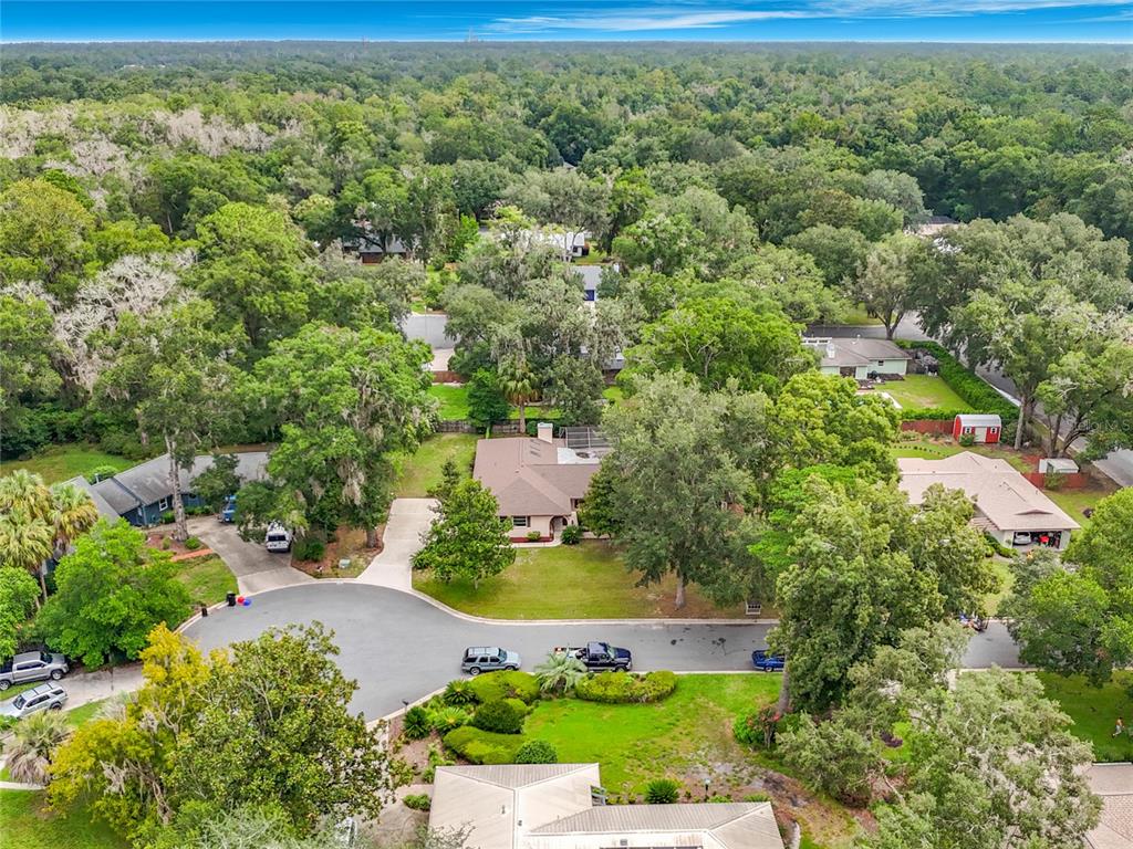 An aerial view shows several suburban houses surrounded by dense trees and a cul-de-sac — 3944 NW 40TH COURT, GAINESVILLE, FL